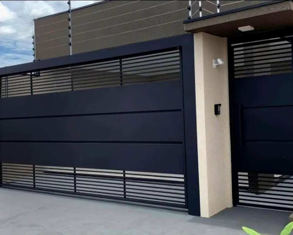 Portão basculante preto com social separado em casa de cliente